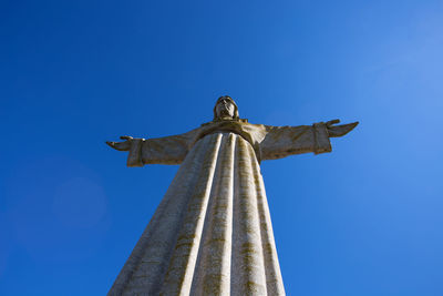 Low angle view of jesus christ statue against clear blue sky