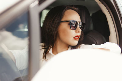 Woman wearing sunglasses in car