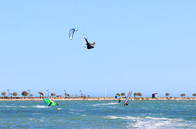 Man kiteboarding over sea against sky