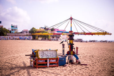 Amusement play equipment at beach against sky
