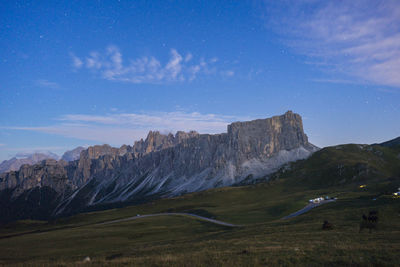 Scenic view of landscape and mountains against blue sky