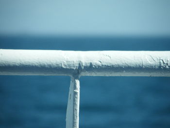 Close-up of metal structure in sea against sky