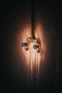 Close-up of electric lamp hanging on ceiling at home