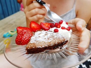Midsection of woman holding dessert in plate
