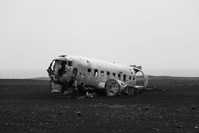 Damaged airplane on field against sky