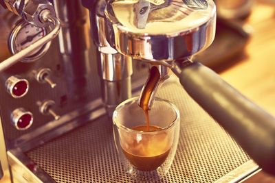 Coffee pouring from espresso maker in cafe