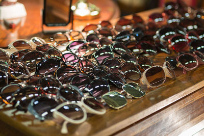 Antique wooden chest of drawers with a collection of vintage women's sunglasses on top