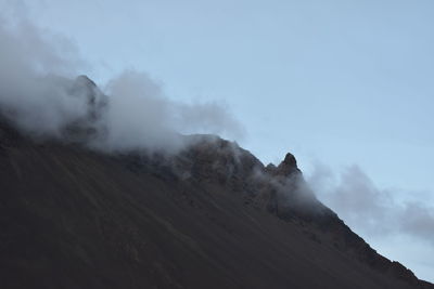 Smoke emitting from volcanic mountain against sky