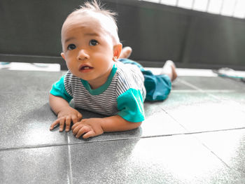 Close-up of cute baby boy on floor at home