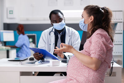 Female friends using mobile phone at clinic