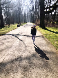 Rear view of man walking on footpath