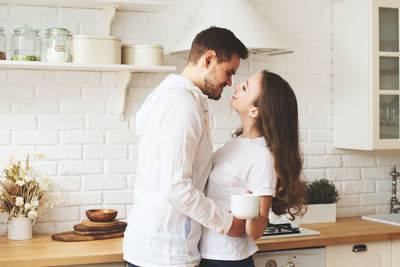 Young couple standing against wall