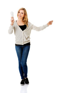 Woman holding equipment during pregnancy test against white background