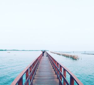 Pier over sea against clear sky