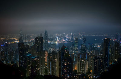 Illuminated cityscape against sky at night