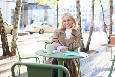 Portrait of young woman sitting on chair