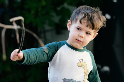 Boy playing with a stick in the garden