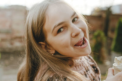 Smiling girl with long hair holding milkshake