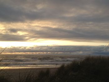 Scenic view of beach against sky during sunset