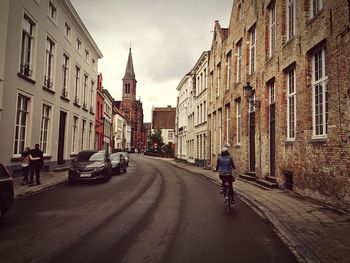Rear view of man riding bicycle on road