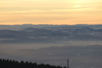 Scenic view of silhouette mountains against orange sky