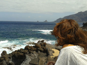 Rear view of woman looking at sea against sky