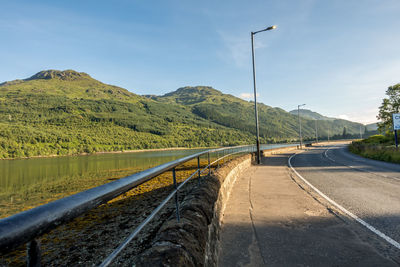 Road by mountain against sky