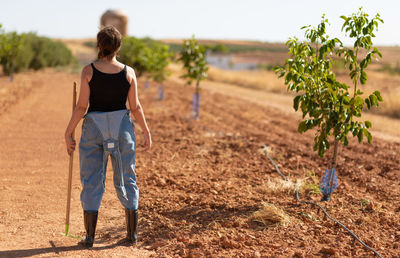 Rear view of woman standing on field