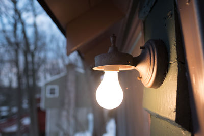 Low angle view of light bulb hanging against sky