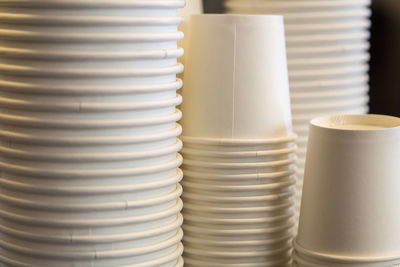 Close-up of stacked white disposable cups on table