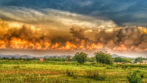 Scenic view of field against cloudy sky