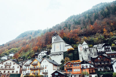 Buildings in town against clear sky during autumn