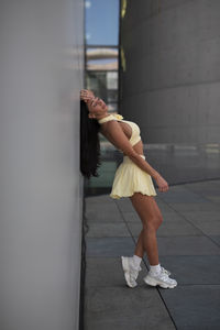 Low section of woman standing against wall