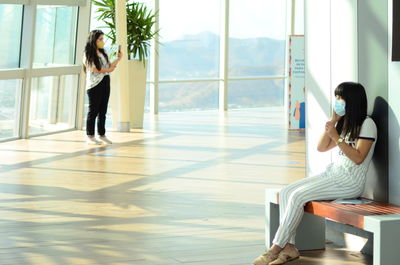 Side view of woman sitting on floor