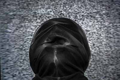 Rear view of person wearing hooded shirt on road