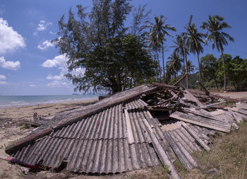 Wooden structure on beach against sky