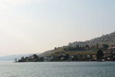 Scenic view of sea by buildings against clear sky