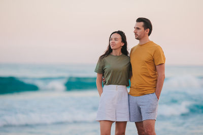 Smiling couple standing at beach