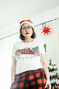 Portrait of young woman standing against white background