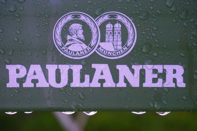 Close-up of wet sign on road