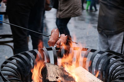 Midsection of man holding fire standing on wood