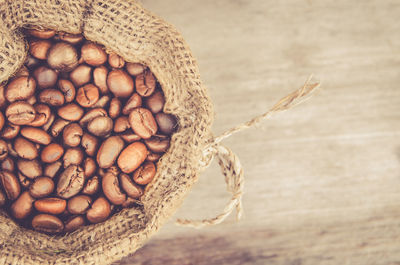 Directly above shot of roasted coffee beans in sack on table