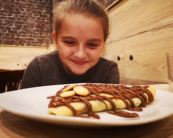 Girl looking at food on plate at restaurant 