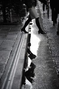 Low section of people walking on footpath in city