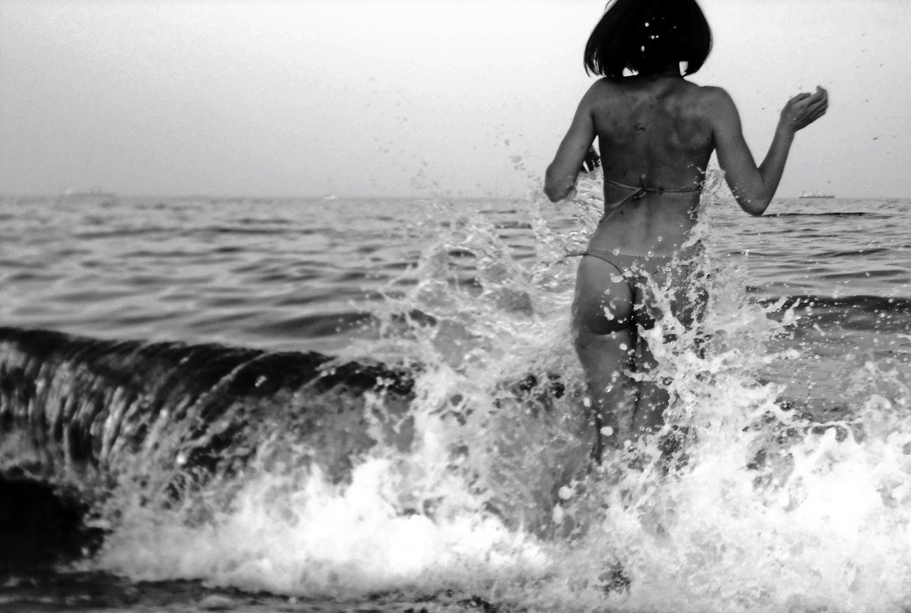 water, sea, horizon over water, wave, leisure activity, lifestyles, beach, motion, splashing, surf, vacations, waterfront, clear sky, full length, nature, young adult, shore, scenics