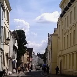 Buildings in city against cloudy sky