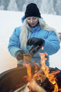 Woman pouring hot drink at winter