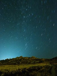 Scenic view of landscape against star field at night