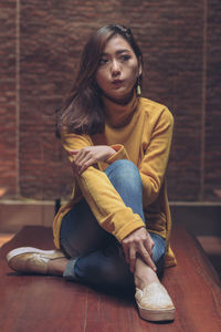 Portrait of a young woman sitting on floor