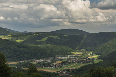 Scenic view of green landscape and mountains against sky